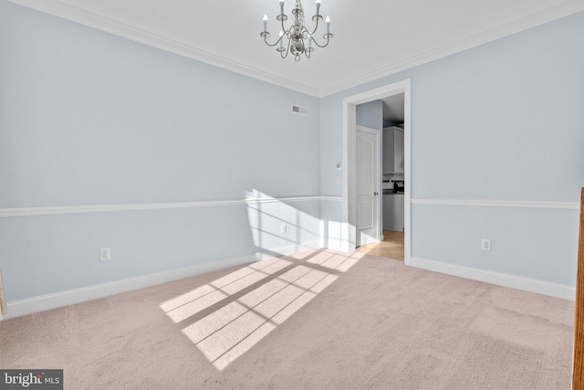 carpeted spare room featuring a notable chandelier and crown molding