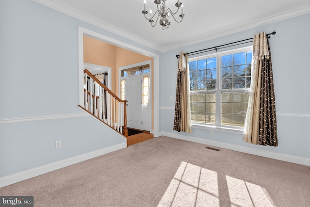 carpeted foyer featuring a notable chandelier and ornamental molding