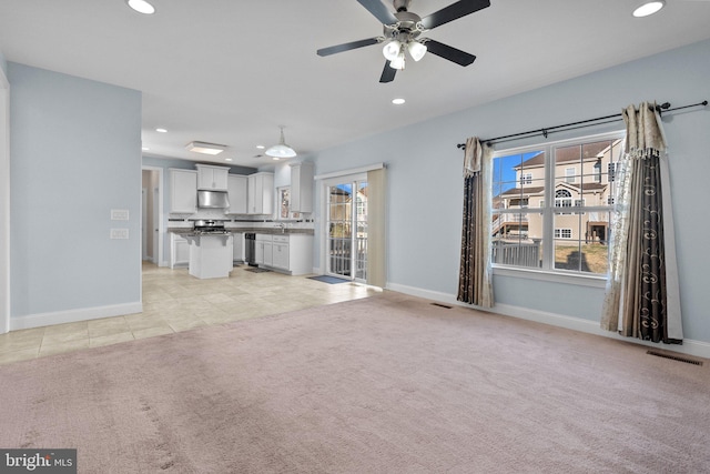 unfurnished living room with light carpet and ceiling fan