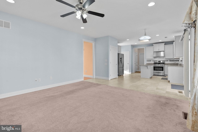 unfurnished living room with light tile patterned flooring and ceiling fan