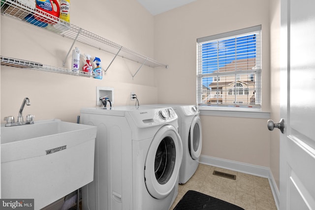 clothes washing area featuring sink and washer and clothes dryer