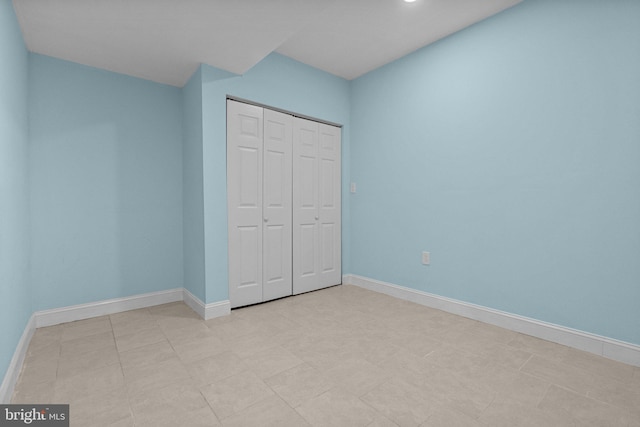 unfurnished bedroom featuring a closet and light tile patterned flooring