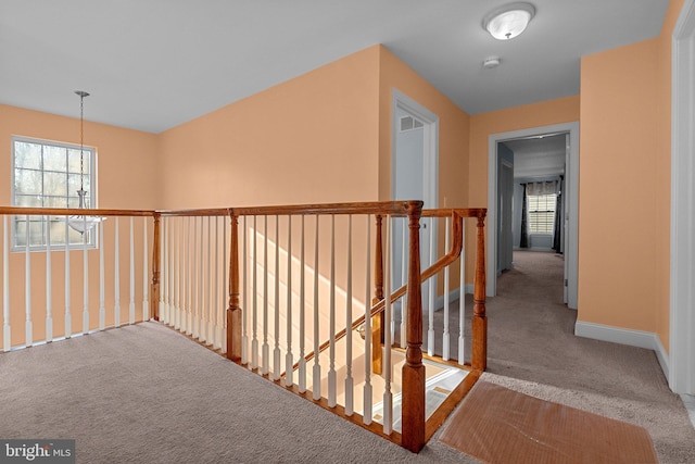 hallway with a chandelier and carpet floors