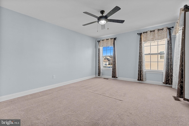 empty room with ceiling fan and light carpet