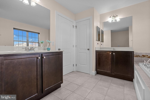 bathroom with a chandelier, a tub to relax in, vanity, and tile patterned floors