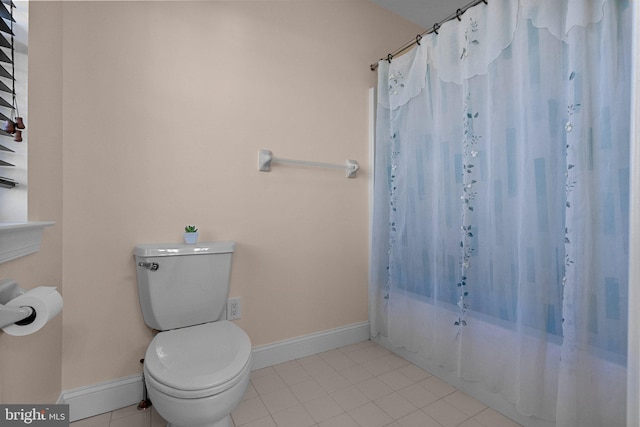 bathroom featuring tile patterned flooring, shower / bath combo, and toilet