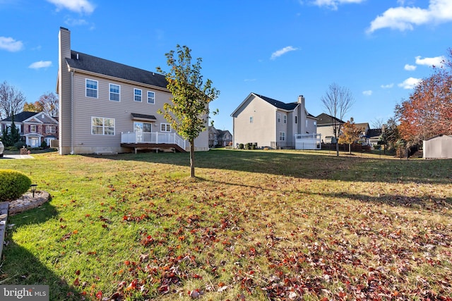 back of house featuring a deck and a lawn