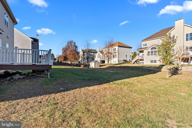 view of yard with a wooden deck and a storage unit