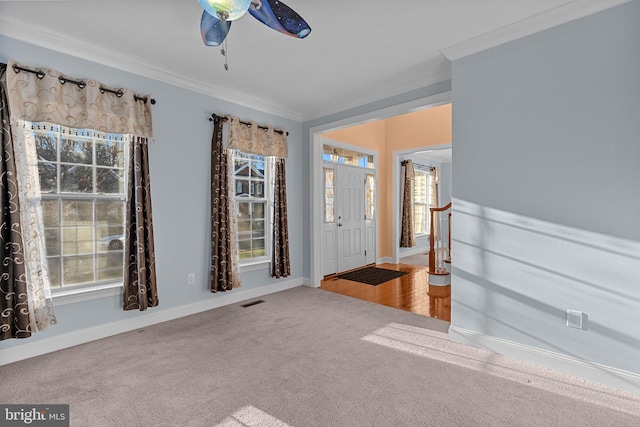 interior space with ceiling fan, carpet floors, and crown molding