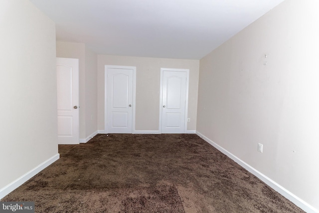 empty room featuring dark colored carpet