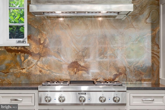 details with extractor fan, white cabinets, and stainless steel gas stovetop