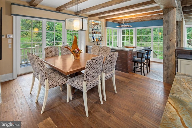 dining space with a wealth of natural light, beam ceiling, and light wood-type flooring