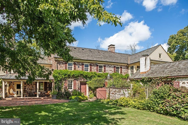 rear view of house featuring a yard and a patio area