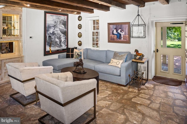 living room featuring a chandelier and beam ceiling