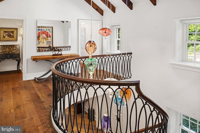 stairs featuring hardwood / wood-style floors and vaulted ceiling with beams