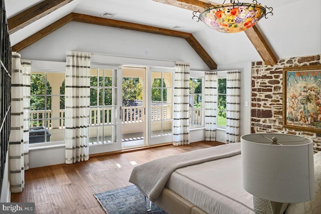 bedroom with lofted ceiling with beams, multiple windows, and wood-type flooring