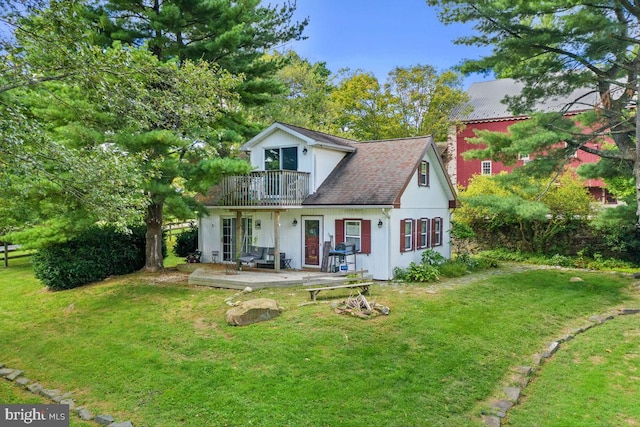 view of front of house featuring a front yard and a balcony