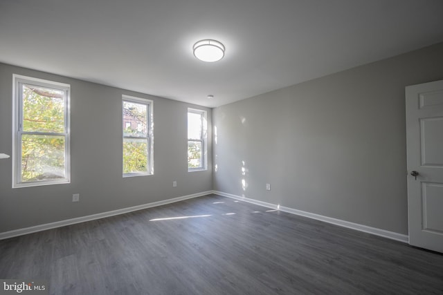 unfurnished room with dark hardwood / wood-style flooring