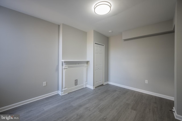 unfurnished bedroom with a closet and dark wood-type flooring