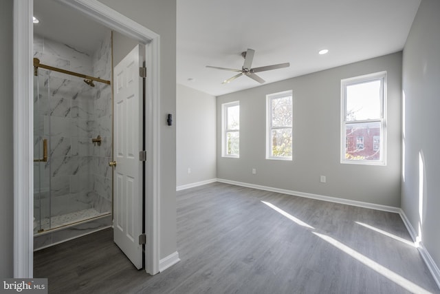 bathroom with hardwood / wood-style floors, ceiling fan, and an enclosed shower