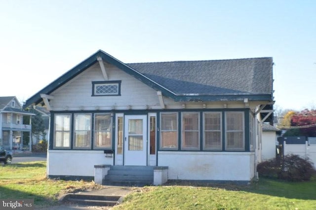 rear view of property with a sunroom and a yard