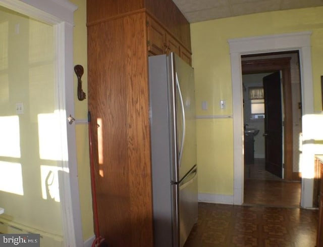 kitchen with dark parquet floors and stainless steel fridge