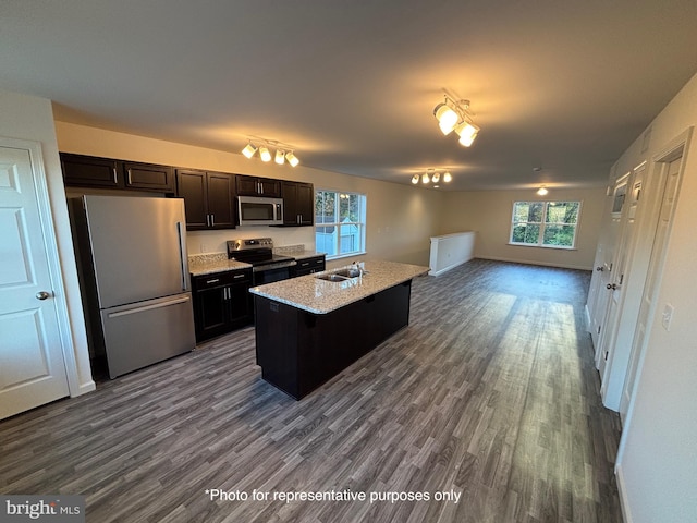 kitchen with a center island with sink, a kitchen breakfast bar, sink, appliances with stainless steel finishes, and wood-type flooring