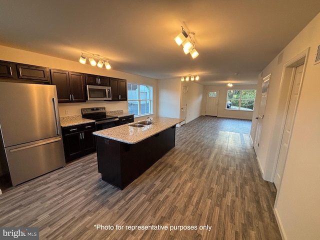 kitchen featuring a center island, sink, hardwood / wood-style flooring, appliances with stainless steel finishes, and a kitchen bar