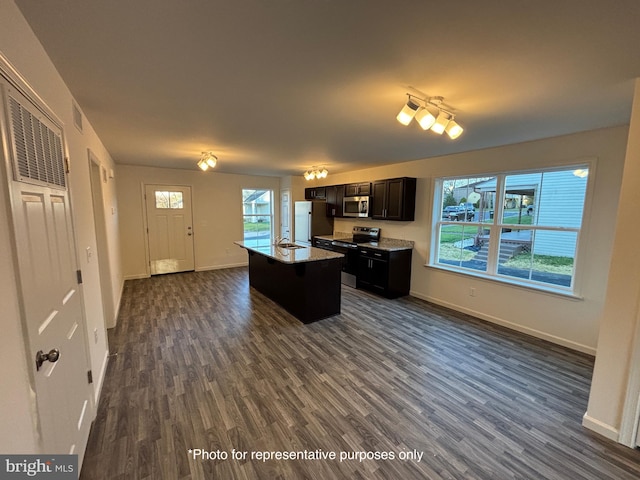 kitchen with dark hardwood / wood-style flooring, an island with sink, stainless steel appliances, and sink