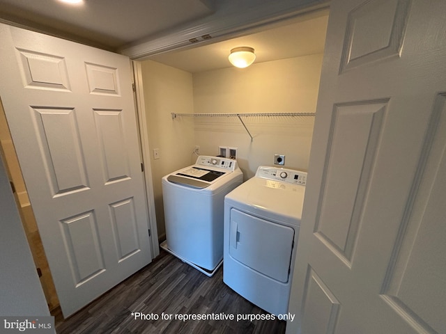 laundry room with washing machine and clothes dryer and dark hardwood / wood-style floors