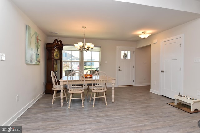 dining space with a chandelier and hardwood / wood-style floors