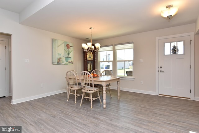 dining space with wood-type flooring and a notable chandelier