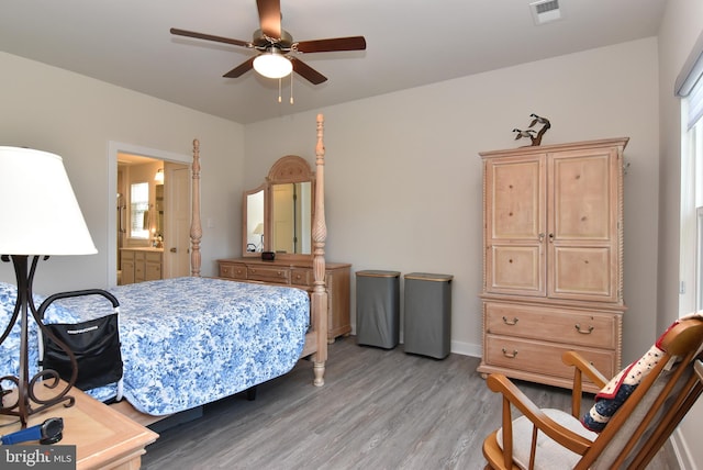 bedroom featuring light wood-type flooring, ensuite bath, multiple windows, and ceiling fan