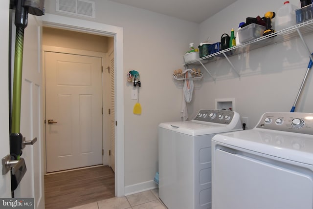 washroom with independent washer and dryer and light hardwood / wood-style floors