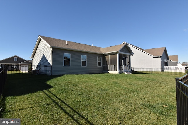 rear view of property featuring a lawn and a sunroom