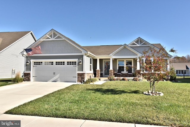 craftsman house with a garage, a front lawn, and covered porch