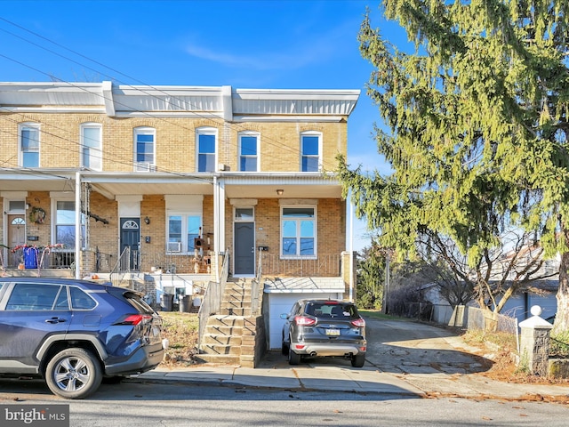 multi unit property featuring covered porch and a garage