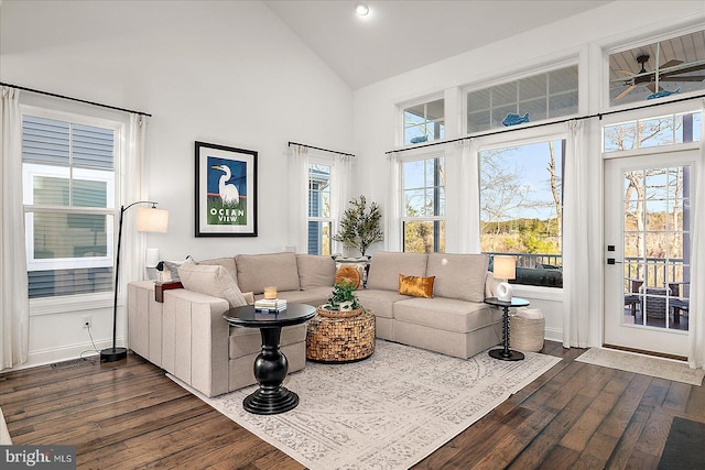 interior space featuring baseboards, high vaulted ceiling, and dark wood finished floors