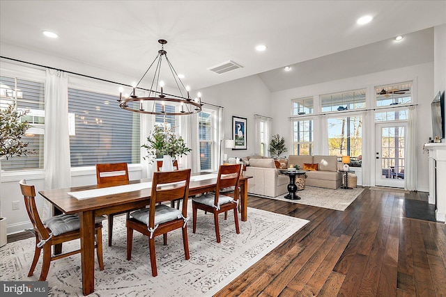 dining space with lofted ceiling, recessed lighting, visible vents, dark wood-style floors, and an inviting chandelier