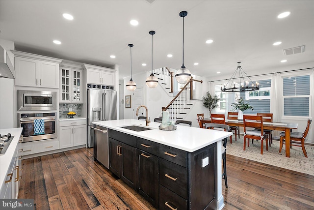 kitchen featuring visible vents, stainless steel appliances, light countertops, white cabinetry, and a sink