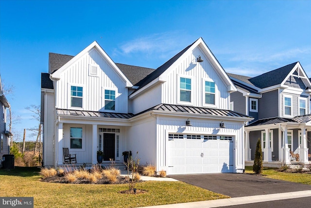 modern farmhouse with a garage, a standing seam roof, and board and batten siding