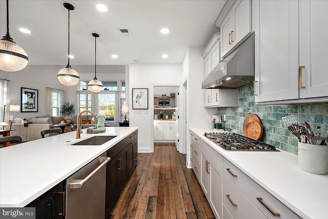 kitchen with visible vents, stainless steel appliances, light countertops, under cabinet range hood, and a sink