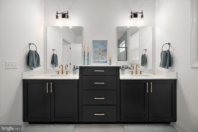 bathroom featuring baseboards, two vanities, and a sink