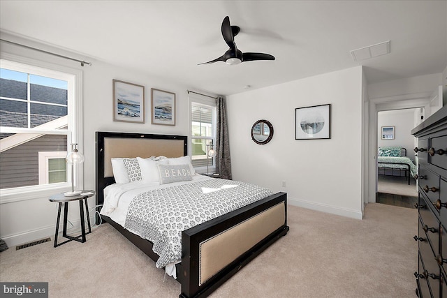 bedroom featuring visible vents, light carpet, and baseboards