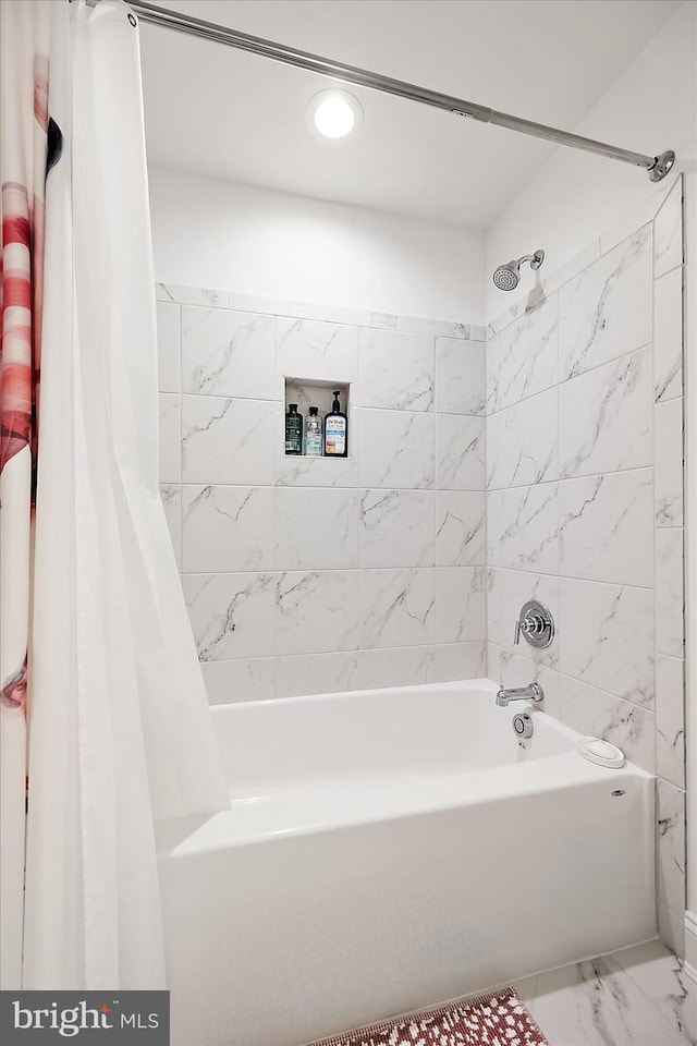 full bath featuring shower / tub combo and marble finish floor