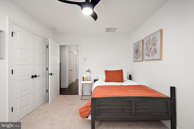 bedroom featuring carpet floors, a closet, visible vents, and a ceiling fan