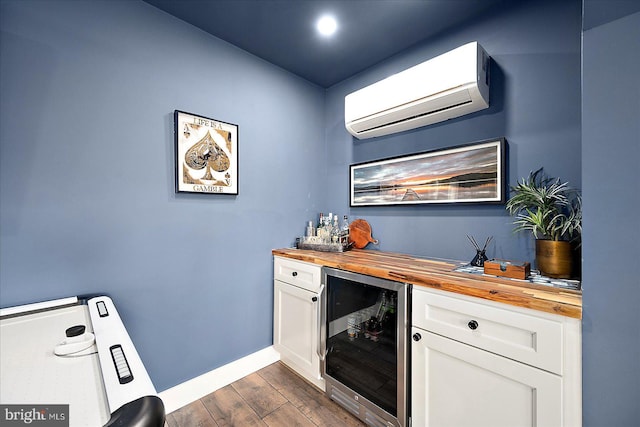 bar with wine cooler, dark wood-type flooring, baseboards, a dry bar, and a wall mounted air conditioner