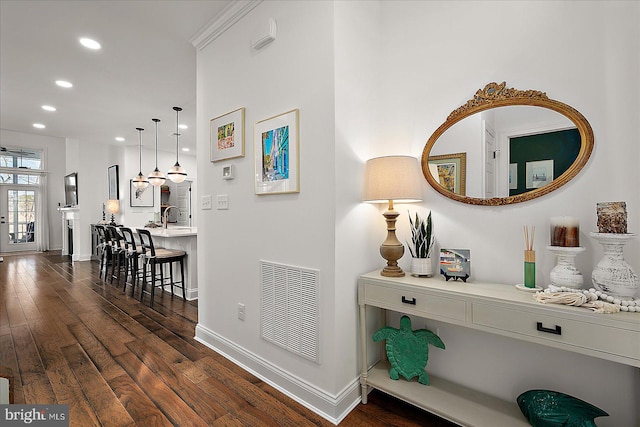 hallway featuring dark wood-style floors, baseboards, visible vents, and recessed lighting