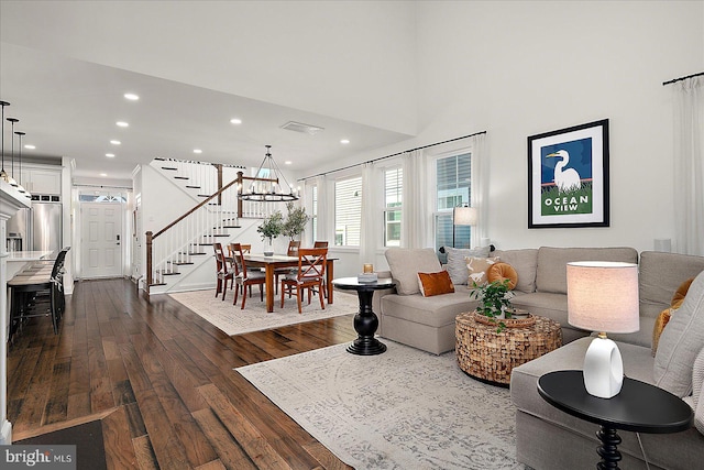 living room featuring visible vents, a towering ceiling, dark wood-style floors, stairs, and recessed lighting