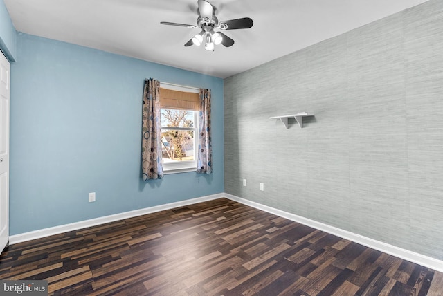 spare room featuring dark hardwood / wood-style flooring and ceiling fan